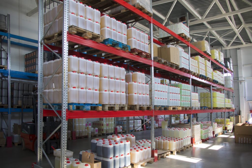 warehouse of stored chemicals in plastic containers on metal shelving