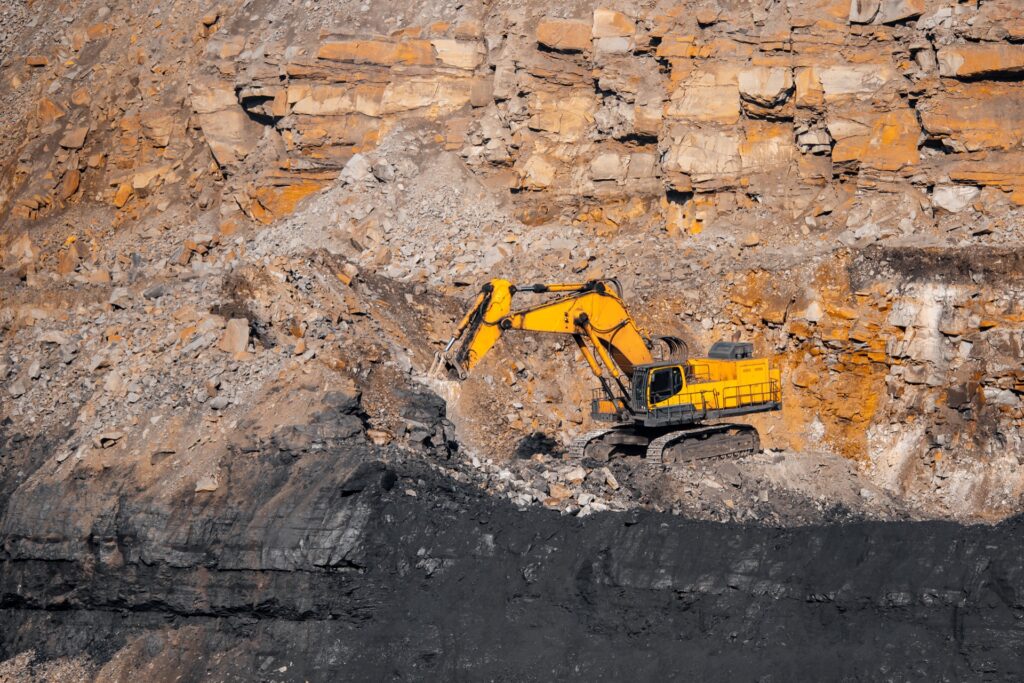 Excavator mining aluminum in open pit mine