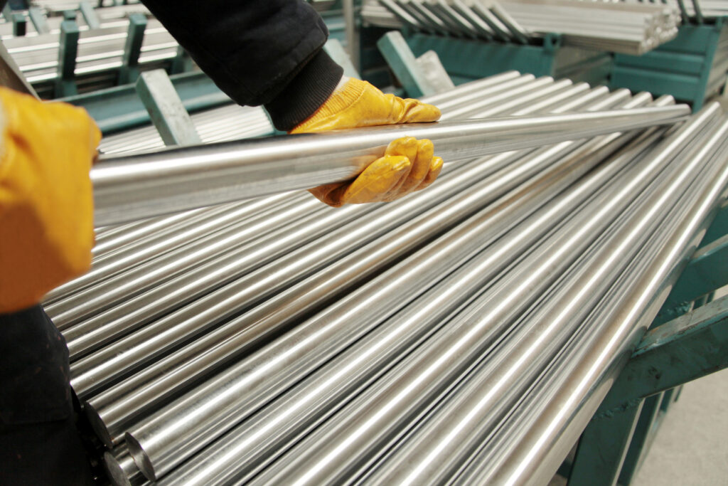 Worker grabbing industrial steel pipe in Kelowna